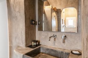 a bathroom with a sink and a mirror at Aletro Cottage Houses in Mikonos