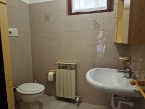 La petite salle de bains est pourvue de toilettes et d'un lavabo. dans l'établissement Omary, à Colà