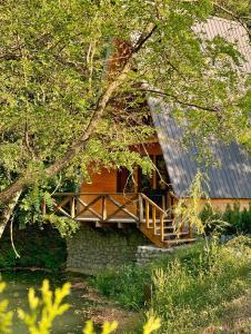eine Blockhütte mit einer Veranda und einer Holzterrasse in der Unterkunft Chateau Kiramala in Lagodechi