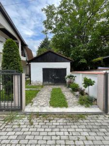 uma casa com garagem e uma entrada de tijolos em Stefan's Cozy Skopje House em Skopje
