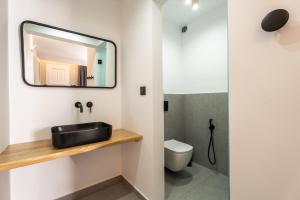 uma casa de banho com um lavatório e um espelho em Lofos Village em Ios Chora