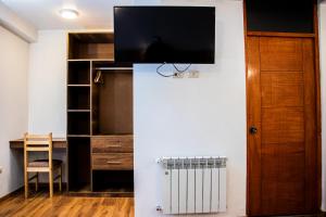 una stanza con una scrivania e una TV a parete di Estancia San Pedro Hotel a Cuzco