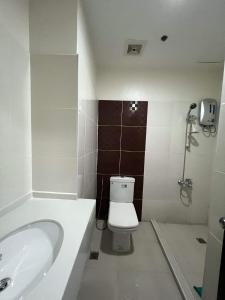 een badkamer met een bad, een toilet en een wastafel bij San Remo Oasis and Bamboo Bay Condominium in Mandaue-stad