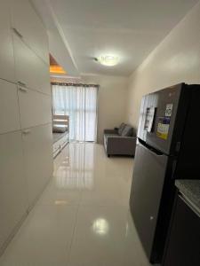 een keuken en een woonkamer met een koelkast bij San Remo Oasis and Bamboo Bay Condominium in Mandaue-stad