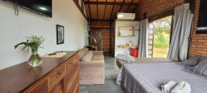 a bedroom with a bed and a couch in a room at Hospedagem Pé de Serra in Botucatu