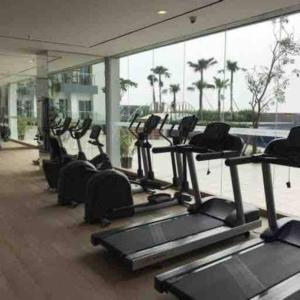 een fitnessruimte met een rij cardio-apparaten in een gebouw bij Oriental La Casa V at Anderson in Surabaya