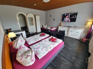 a bedroom with two beds and a living room at Pension Hamburg in Bad Grund
