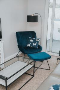 a blue chair sitting in a living room at Causeway Coast Sea Shore Apartment - Ballycastle in Ballycastle