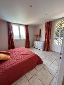 1 dormitorio con 1 cama roja y 2 ventanas en Maison familiale, avec vue imprenable, en Montauroux