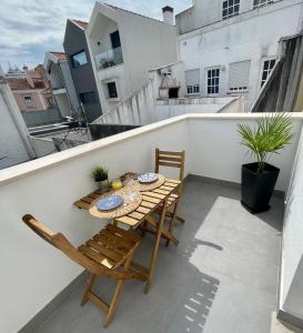 einen Balkon mit einem Tisch und Stühlen auf dem Dach in der Unterkunft Casita São Gonçalinho by Home Sweet Home Aveiro in Aveiro