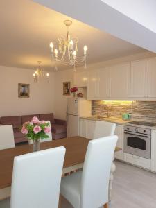 a kitchen and dining room with a table and white cabinets at Apartment Elizabeth in Split