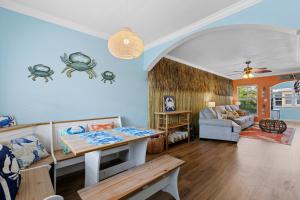 uma sala de estar com uma mesa e um sofá em Tiki Blue Crab Cabana Beach Condo in Paradise em Clearwater Beach