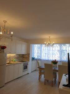 eine Küche mit weißen Schränken, einem Tisch und einem Fenster in der Unterkunft Apartment Elizabeth in Split