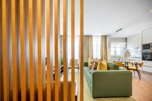 un soggiorno con divano verde e una cucina di Casas do Porto - Ribeira Apartments a Porto
