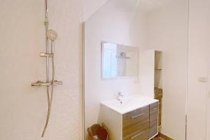 a white bathroom with a sink and a shower at Le Palais Riviera in Nice