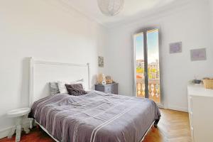 a white bedroom with a large bed and a window at Le Palais Riviera in Nice