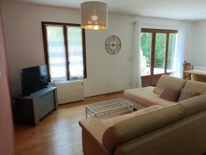a living room with a couch and a tv at La maison du bois, 10 minutes de l'A71, 10 minutes de Bourges in Plaimpied-Givaudins