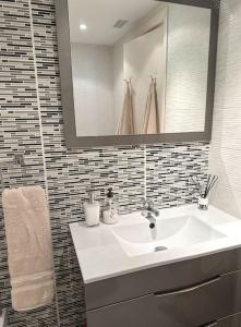uma casa de banho com um lavatório branco e um espelho. em Elegant 2-bedroom apartment with beautiful views em Benalmádena
