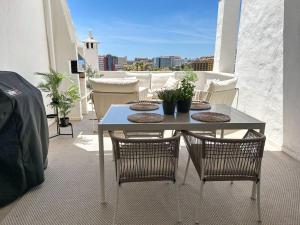 um pátio com uma mesa e cadeiras numa varanda em Elegant 2-bedroom apartment with beautiful views em Benalmádena
