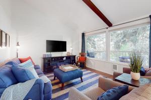 a living room with blue furniture and a large window at Calamity Cabin in Gig Harbor