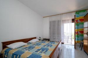 Un dormitorio con una cama y una ventana grande. en Kuća Zora, en Zaglav