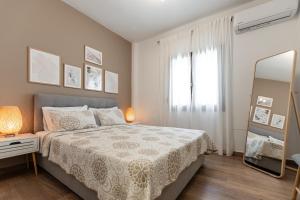 a white bedroom with a bed and a mirror at Naxos Alma House in Naxos Chora