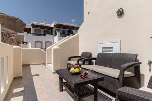 a patio with a couch and a table on a balcony at Naxos Alma House in Naxos Chora