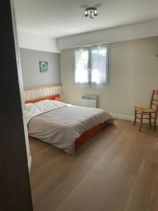 ル・プリガンにあるLe Pouliguen/La Baule Appartement T3のベッドルーム1室(ベッド1台、椅子、窓付)