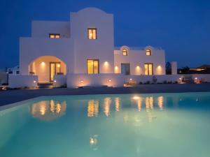 a villa with a swimming pool at night at Bonsai Luxury Suites in Karterados