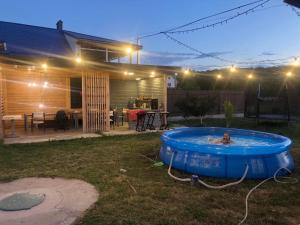 a person in a pool in a backyard at night at Приватна садиба in Kamianets-Podilskyi