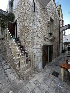 un bâtiment en pierre avec un escalier sur son côté dans l'établissement Casa Pietra Viva, à Cisternino