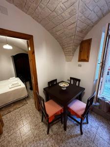 Zimmer mit einem Tisch, Stühlen und einem Bett in der Unterkunft Casa Pietra Viva in Cisternino