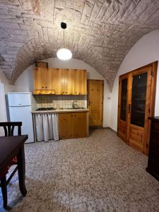 eine Küche mit Holzschränken und einem weißen Kühlschrank in der Unterkunft Casa Pietra Viva in Cisternino
