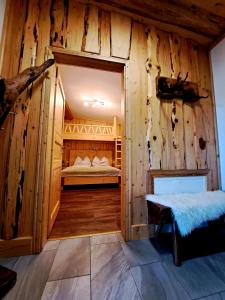 1 dormitorio en una cabaña de madera con 1 cama. en Erlebnisbauernhof Gutschi Ranch en Kamp