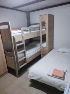 a room with three bunk beds and a bed at Kutak na Drini in Mali Zvornik