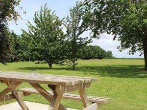 uma mesa de piquenique de madeira num campo com árvores em Guestroom Cravant, 1 pièce, 2 personnes - FR-1-590-301 em Cravant