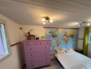 a bedroom with a purple dresser and a world map at Chalet dans le vert in Gassin