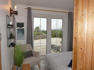 a bedroom with a bed and a sliding glass door at Carol Cottage in Newry