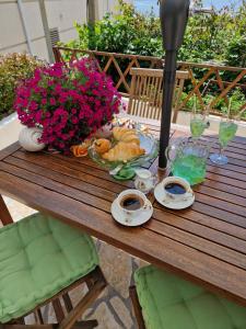 een houten tafel met een kom eten en bloemen erop bij Bel Posto Apartment in Dubrovnik