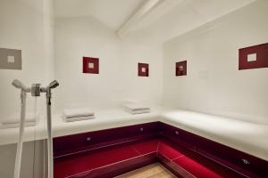 a bathroom with red and white walls and a red sink at AC Hotel by Marriott Innsbruck in Innsbruck