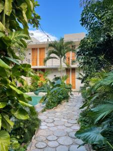 un jardín con una pasarela de piedra frente a un edificio en Colonte Hotel Origen en Valladolid