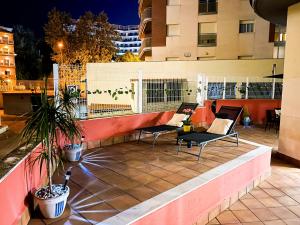 a rooftop patio with two chairs and a plant at Grand Apartament Lloret in Lloret de Mar