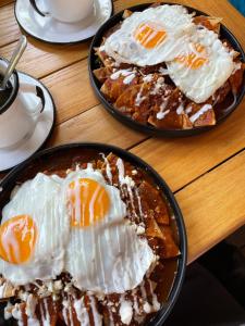 dois pratos de waffles com ovos numa mesa de madeira em Colonte Hotel Origen em Valladolid