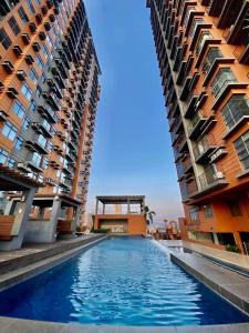 two tall buildings with a swimming pool between them at 2 BR Portovita Tower 12-A in Manila