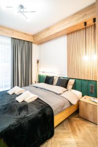 una camera con un grande letto in una stanza con finestre di Apartament Niebiańska Polana by Apart Concept Podhale a Kościelisko