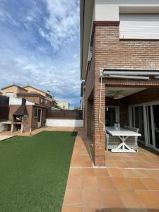 - une terrasse avec une table de pique-nique sur le côté de la maison dans l'établissement Casa con piscina cerca de la playa, à Vidreres