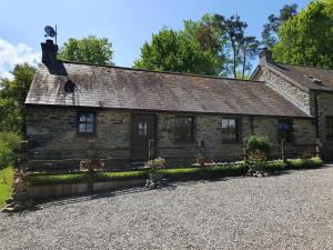 an old stone house with a gravel driveway at Ty Barcud in Lampeter