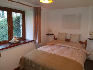 a bedroom with a bed and a window at Ty Barcud in Lampeter