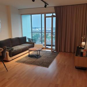una sala de estar con un sofá y una mesa en STUNNING VIEW APARTMENT NEAR FERRY TO SMILTYNĖ, en Klaipėda