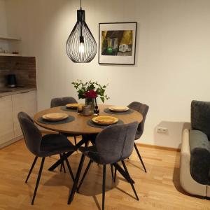 Una mesa de comedor y sillas en una sala de estar. en STUNNING VIEW APARTMENT NEAR FERRY TO SMILTYNĖ, en Klaipėda